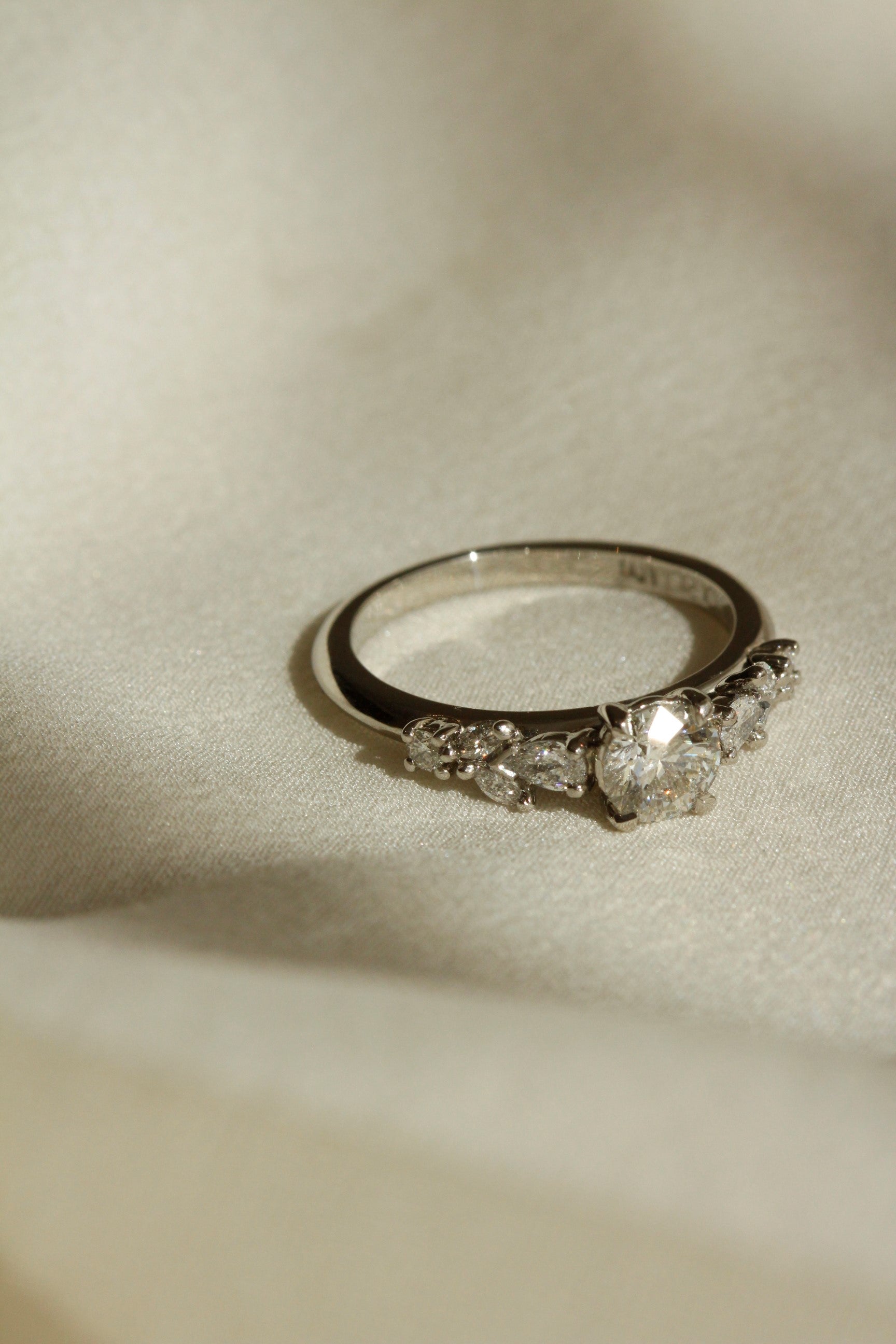 inverted image of Nesso engagement ring in 18k white gold with diamond solitaire and diamonds on the band